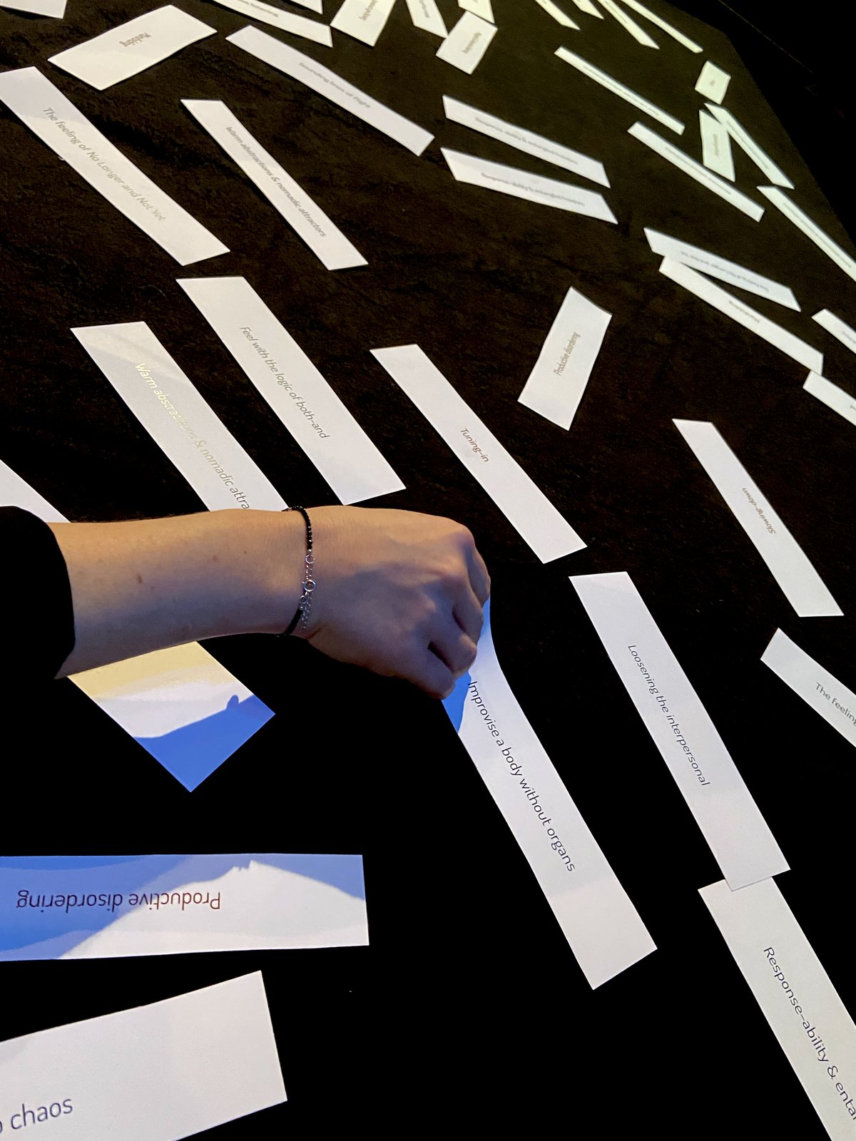 Hand arranging concept-strips on a black tabletop in the AMIS lab